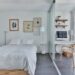 minimalist small apartment bedroom with no headboard, gallery art on walls, desk nook