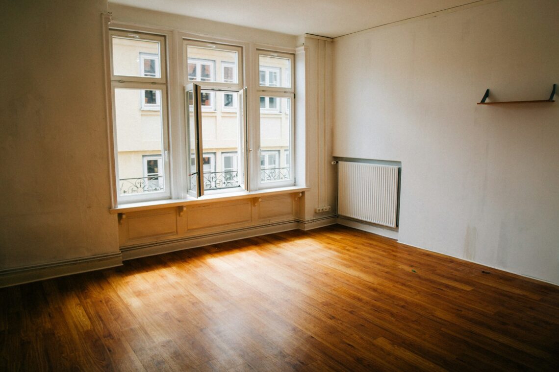 Empty first apartment with hardwood floors waiting to be furnished by a college graduate