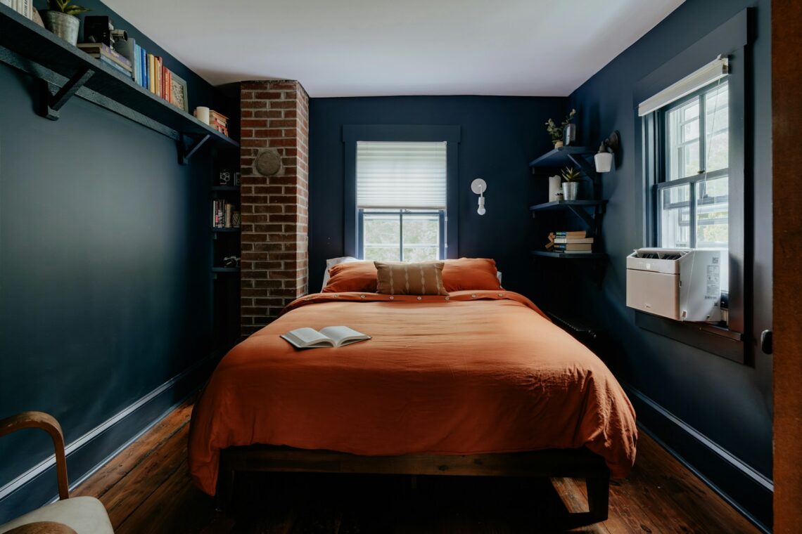 Small NYC apartment bedroom with window AC unit and renter friendly decor