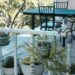 Small balcony railing with succulent planters and a table in the background