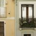 Colorful European apartment building facades with small flower-filled wrought-iron balconies