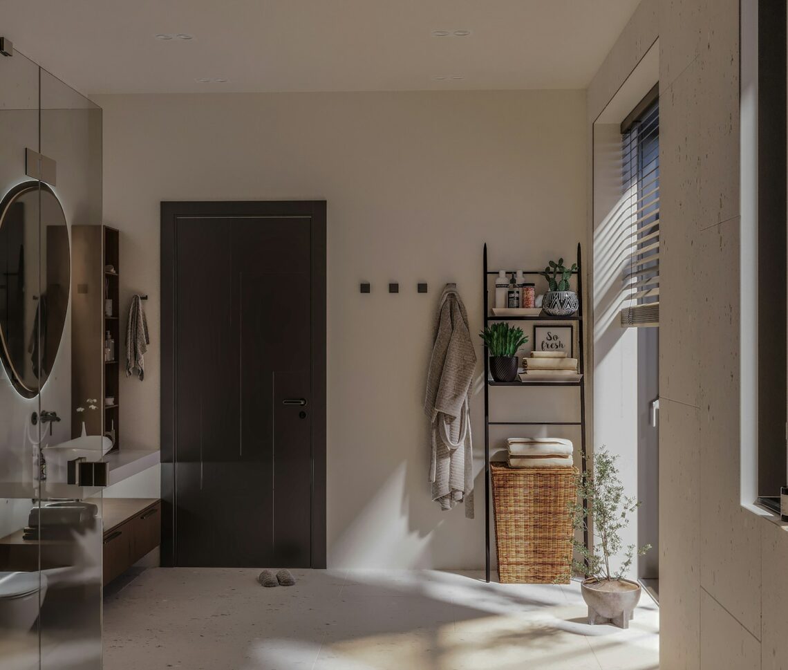 Cozy rental bathroom with robe, ladder shelf, and plant in warm neutral tones