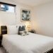 small apartment decor for single woman with white bedding and palm art