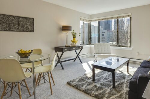 Small apartment living room with round glass dining table and city view