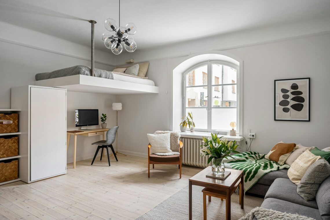 bright 300 sq ft studio apartment with loft bed sofa and desk by window