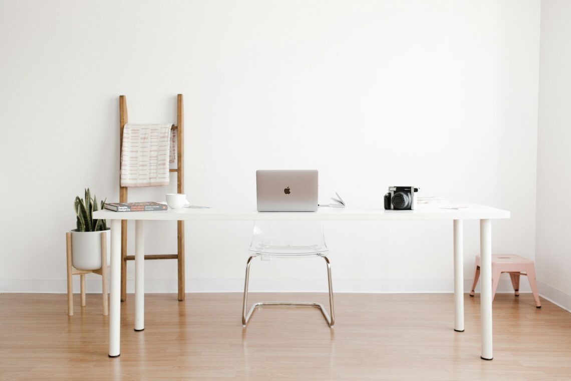 clean white compact desk with laptop in a small studio apartment