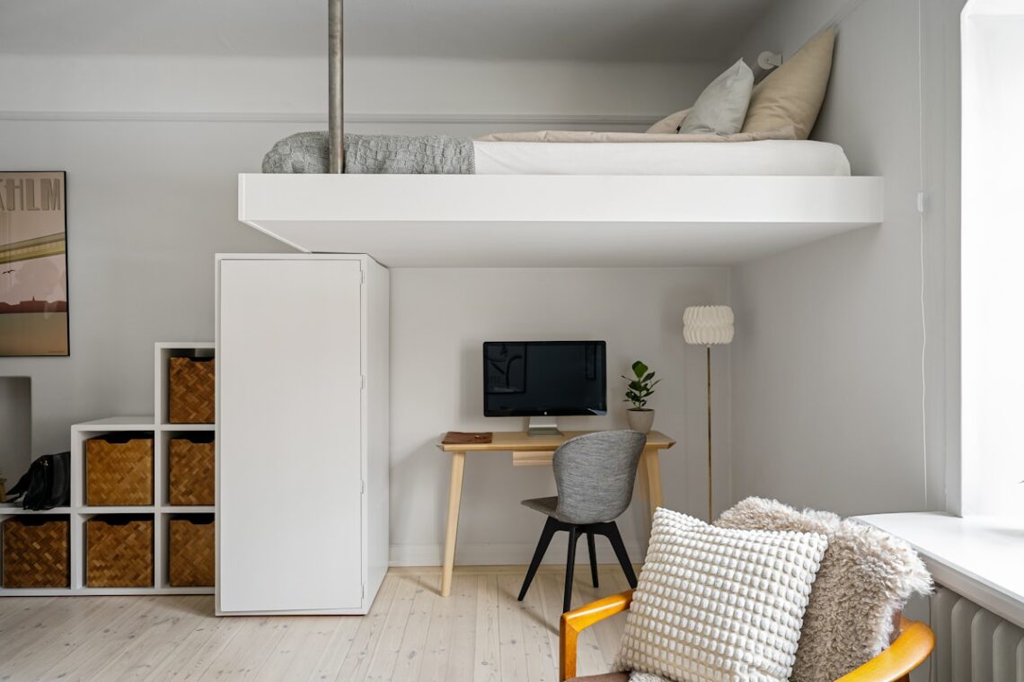 Minimalist studio apartment with loft bed and cube storage units showing smart small-space storage for renters