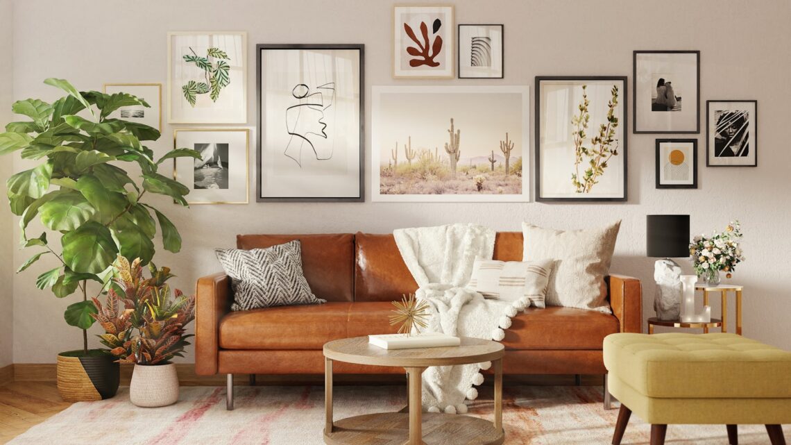 Boho small apartment living room with tan leather sofa, layered gallery wall art, fiddle leaf fig, and woven plant baskets on a vintage rug