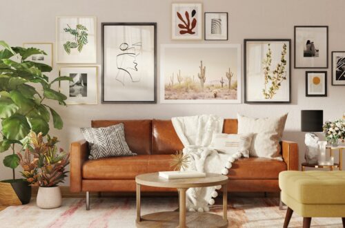 Boho small apartment living room with tan leather sofa, layered gallery wall art, fiddle leaf fig, and woven plant baskets on a vintage rug