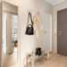 Scandinavian apartment entryway with wall hooks, shoe rack, and full-length mirror near front door
