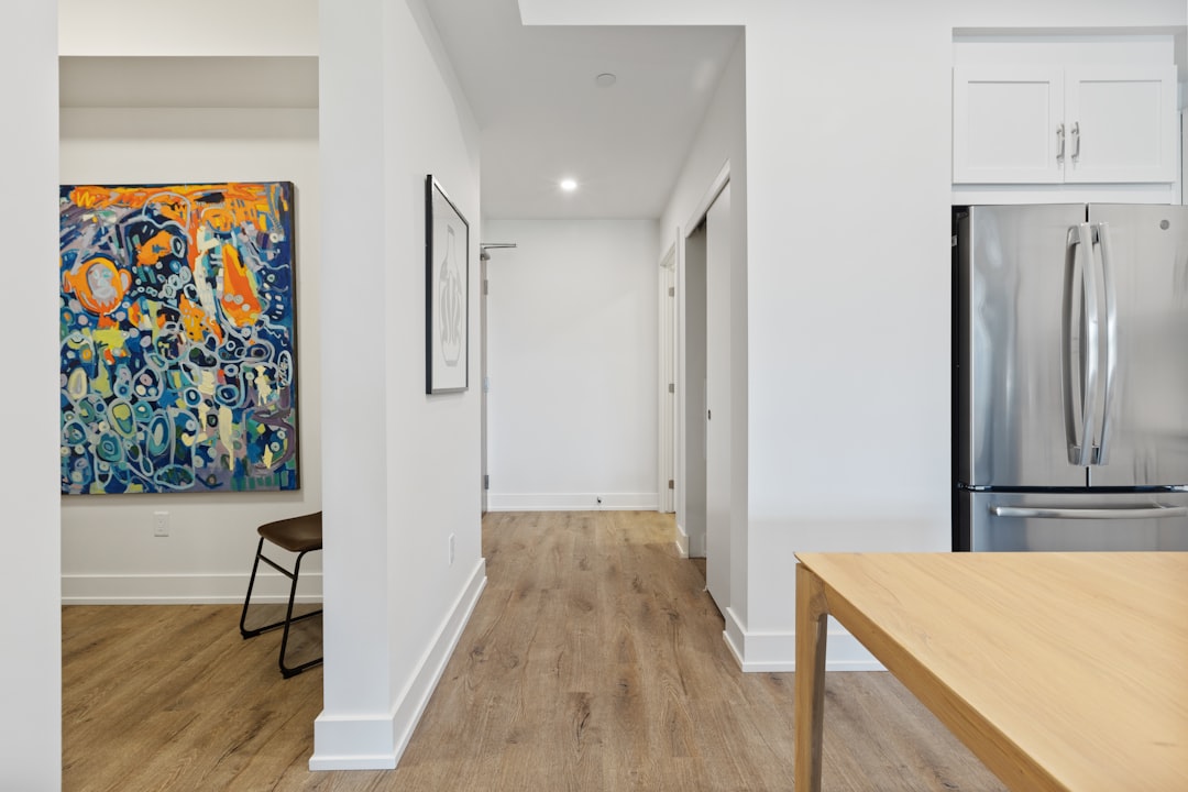 Open-plan apartment interior showing hallway corridor leading from kitchen to front door