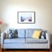 Cozy gray sofa with colorful throw pillows and a floor lamp in a small first apartment living room