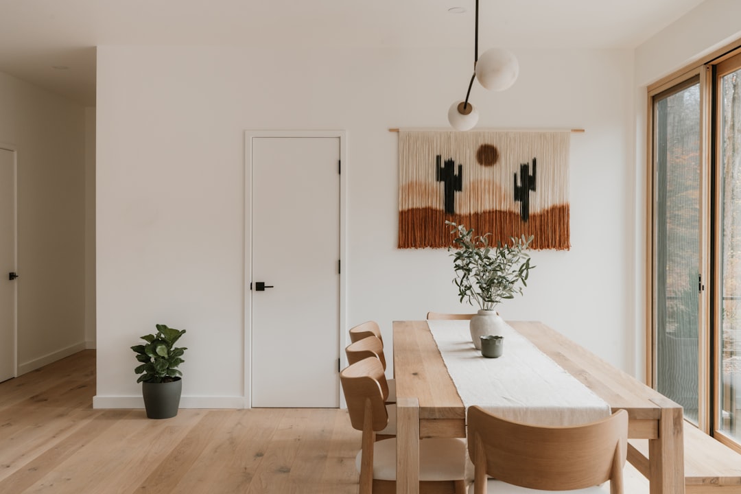 boho dining room with globe pendant light over wooden dining table and macrame wall hanging
