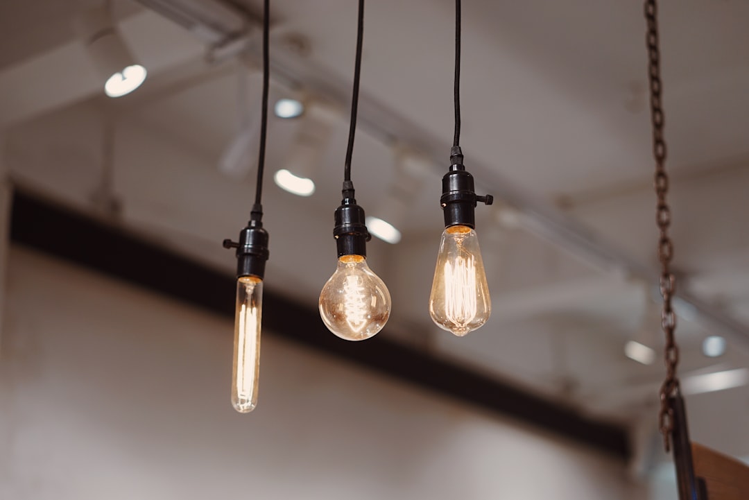 three Edison filament bulbs hanging from black cords showing vintage industrial pendant style