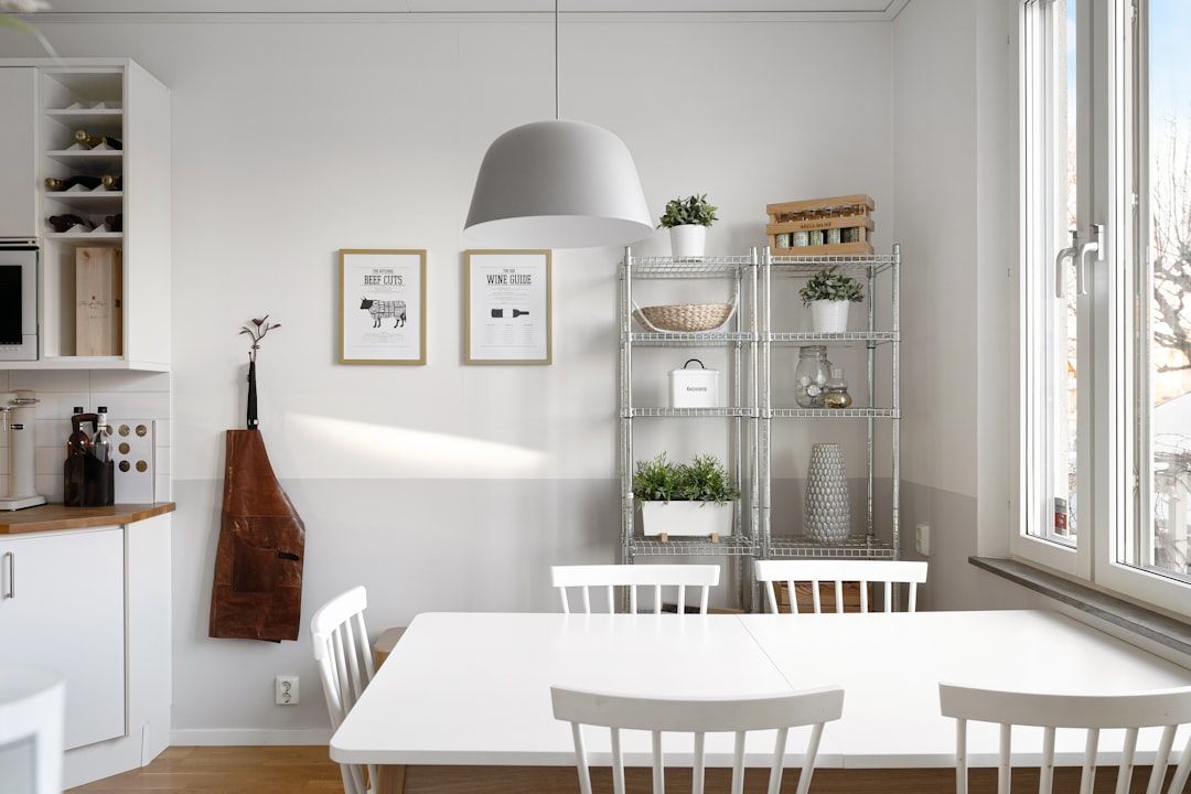 scandinavian apartment kitchen with large white dome pendant over dining table and metal shelving