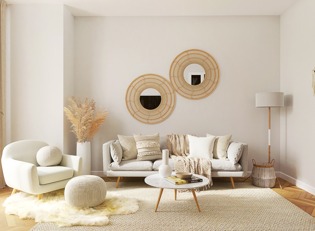 Two round rattan-framed mirrors arranged on a white wall above a gray sofa in a cozy boho apartment living room