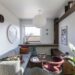Cozy small apartment living room with sofa, shelving, pendant lamp and plants