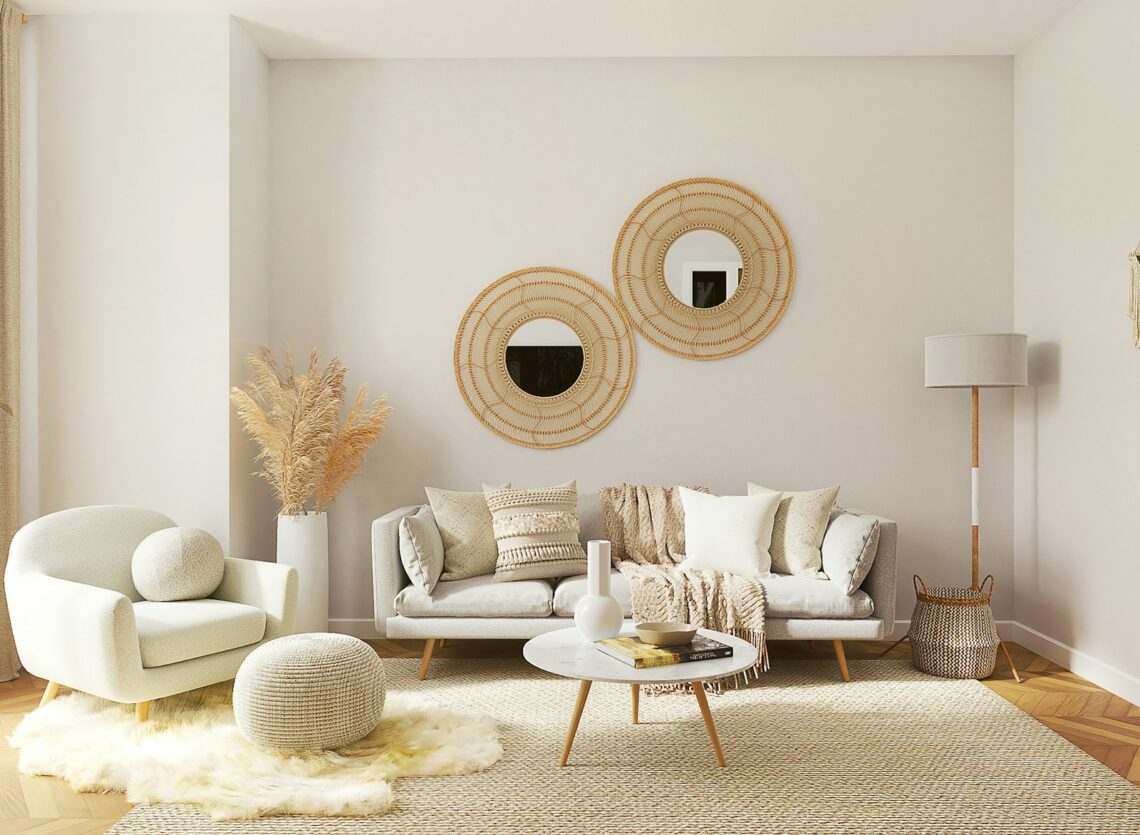Cozy boho small apartment living room with rattan mirrors, gray sofa, pampas grass, and warm neutral tones