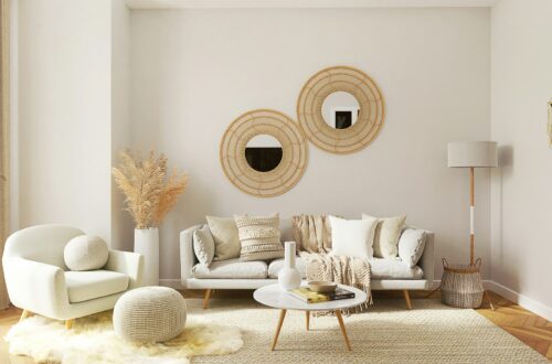 Cozy boho small apartment living room with rattan mirrors, gray sofa, pampas grass, and warm neutral tones