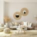 Cozy boho small apartment living room with rattan mirrors, gray sofa, pampas grass, and warm neutral tones
