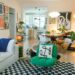 Eclectic studio apartment living room with a fluffy dog resting on a patterned rug surrounded by colorful art and plants