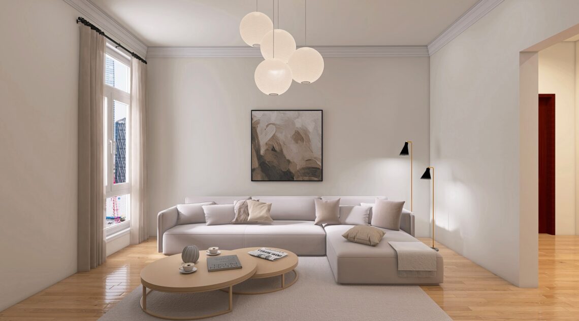 Warm minimalist small apartment living room with cream linen sofa, paper globe pendant lights, soft neutral art, and light wood floor