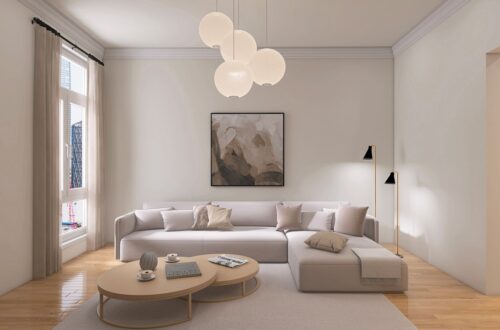 Warm minimalist small apartment living room with cream linen sofa, paper globe pendant lights, soft neutral art, and light wood floor