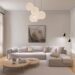 Warm minimalist small apartment living room with cream linen sofa, paper globe pendant lights, soft neutral art, and light wood floor